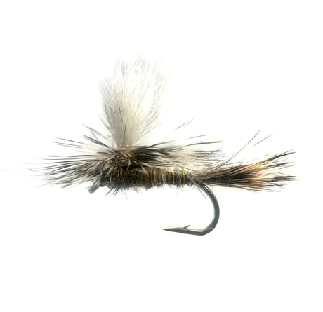 A close-up photograph of the Parachute Hare's Ear dry fly shown in a variety of sizes (#10, #12, #14, #16, and #18). The flies feature buggy hare's ear dubbing bodies, a high-visibility white parachute post, and grizzly hackle, ideal for a versatile presentation in the surface film.