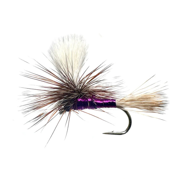 A close-up photograph showing the Sparkling Purple Haze Dry Fly in sizes #10, #12, #14, #16, and #18. The flies feature a purple body with subtle sparkle/flash material, mixed grizzly and brown hackle, and a white parachute post, tied on barbed hooks.